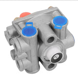 Bottom-angled view of the k070951 relay valve highlighting the exhaust port assembly and clustered side delivery ports with blue dust plugs.