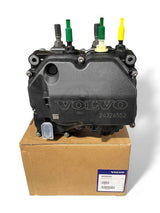 • Front view of the Volvo DEF pump unit 85031447 on top of the original shipping box, showing the branded engraving and color-coded port tips.